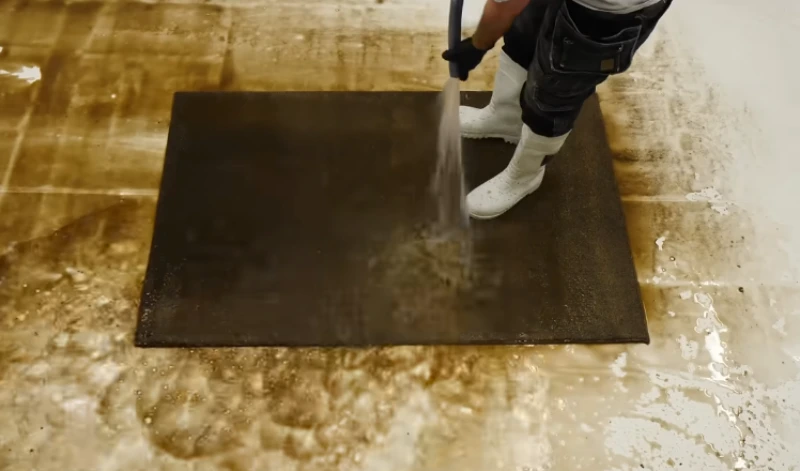 Area rug nearly brown with embedded dirt before professional cleaning