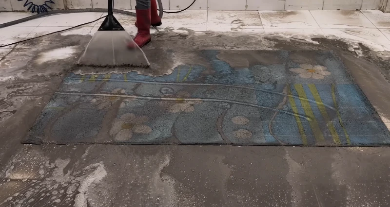 Area rug covered in dirt and cleaning foam before deep carpet cleaning